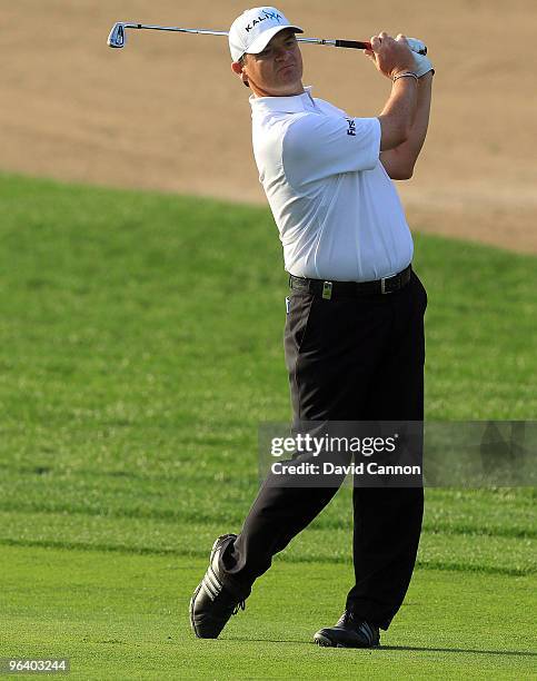 Paul Lawrie of Scotland plays his second shot at the par 4, 12th hole during the first round of the 2010 Omega Dubai Desert Classic on the Majilis...