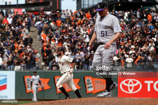 Brandon Belt of the San Francisco Giants rounds the bases after hitting a three run home run off of Jake McGee of the Colorado Rockies during the...