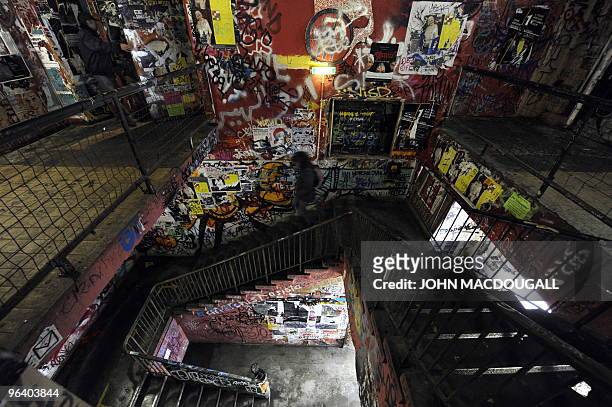 Woman walks down the stairs in the grafitti-covered lobby of the Kunsthaus Tacheles artists' colony in Berlin's Mitte district January 29, 2010. The...