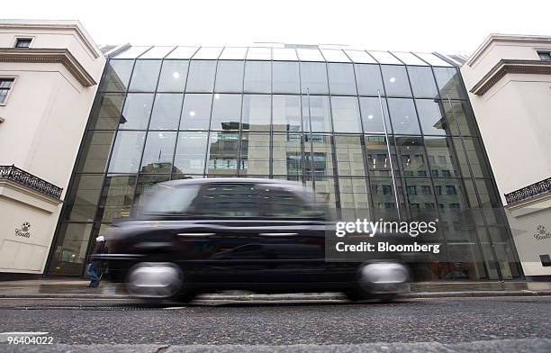 Taxi passes the headquarters of Coutts & Co. The private banking division of the Royal Bank of Scotland Group Plc in London, U.K., on Wednesday, Feb....