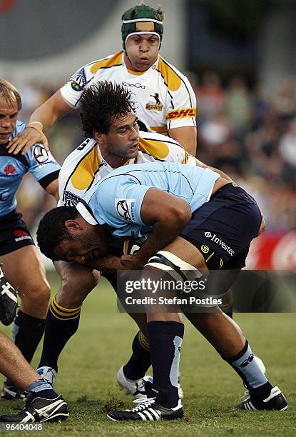 Wycliff Palu of the Waratahs is tackled by George Smith of the Brumbies during the Super 14 trial match between the Brumbies and the Waratahs at...