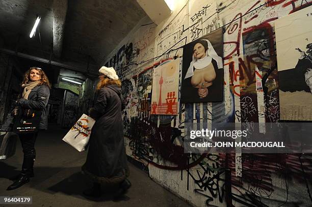 Visitors check out a display outside a gallery showing prints by Dutch artist Tim Roeloffs in the Kunsthaus Tacheles artists' colony in Berlin's...