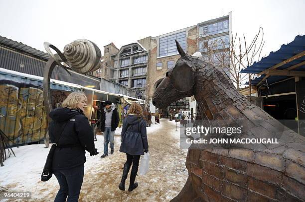 Visitors walk through an open-air gallery displaying sculptures outside the Kunsthaus Tacheles artists' colony in Berlin's Mitte district January 29,...