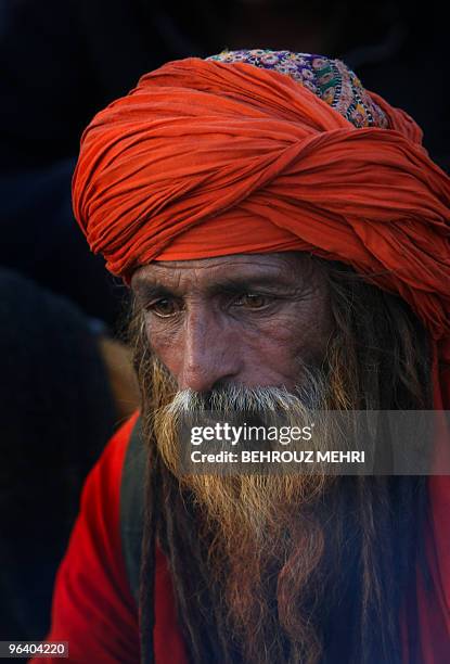 Pakistani Muslim devotee sufi looks on in a Christian grave yard next to the Data Darbar where is the Saint Syed Ali bin Osman Al-Hajvery shrine,...