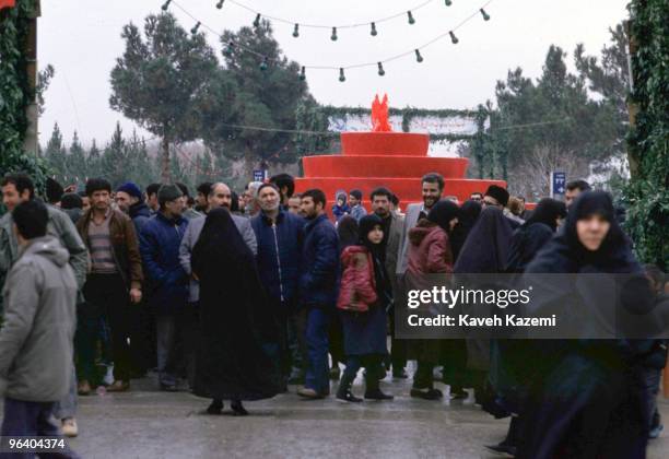 Families at the Behesth-e Zahra cemetery in Tehran, Iran, 1st February 1984. In the background is a fountain of red liquid representing the blood of...