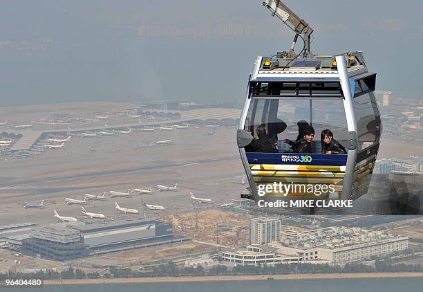 Passengers ride the Ngong Ping cable car in Hong Kong on October 13, 2008. AFP PHOTO/MIKE CLARKE