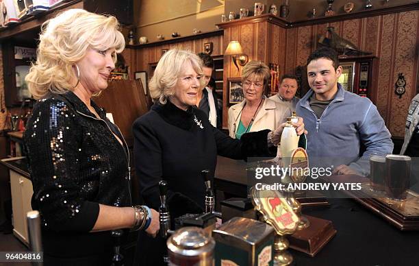Camilla, The Duchess of Cornwall pulls a pint of beer as she meets actors Beverly Callard, who plays landlady Liz McDonald , Anne Kirkbride, who...