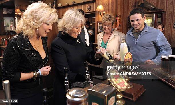 Camilla, The Duchess of Cornwall pulls a pint of beer as she meets actors Beverley Callard, who plays landlady Liz McDonald , Anne Kirkbride, who...