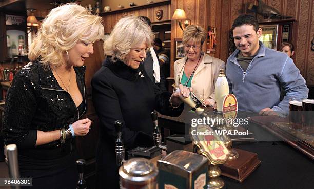 Camilla, The Duchess of Cornwall pulls a pint of beer as she meets actors Beverley Callard, who plays landlady Liz McDonald , Anne Kirkbride, who...