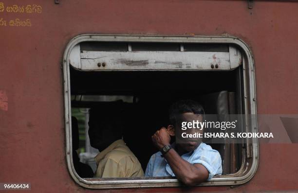 Sri Lankan commuter looks out from a window as he heads to work by train in Kelaniya on January 19, 2010. AFP PHOTO/Ishara S. KODIKARA