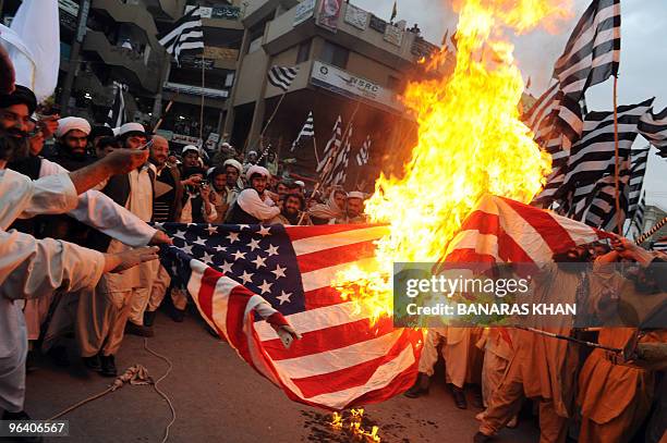 Pakistani supporters of hardline pro-Taliban party Jamiat Ulema-i-Islam-Nazaryati torch a US flag in a protest against the US court verdict against...