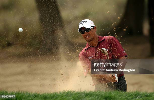 Michael Campbell of New Zealand plays from a bunker on the 11th hole during the first round of the Omega Dubai Desert Classic on February 4, 2010 in...