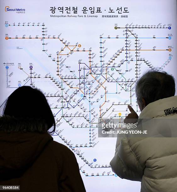 Passengers look at the Seoul metro line map at Chungmuro subway station on line 3 in Seoul on January 24, 2010. AFP PHOTO/JUNG YEON-JE