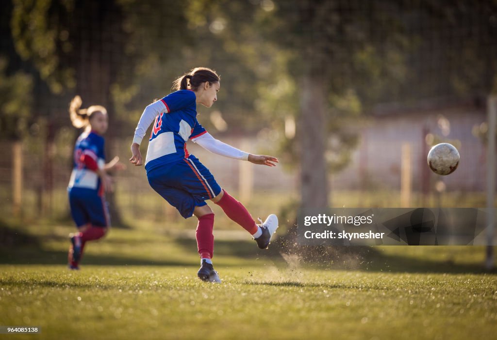 Jogador de futebol adolescentes em ação em um campo de jogo.