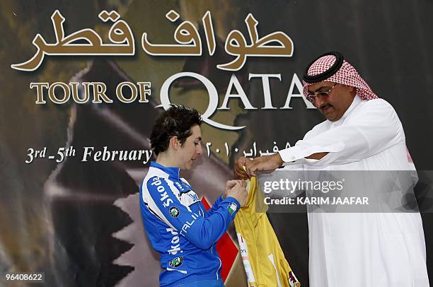 Sheikh Khaled bin Ali al-Thani, president of the Qatar Cycling Federation, gives the gold jersey to Italy's Giorgia Bronzini after she won the second...