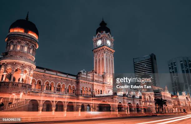 famous place building sultan abdul samad clock tower during dusk with light trail in kuala lumpur - dataran merdeka stock pictures, royalty-free photos & images