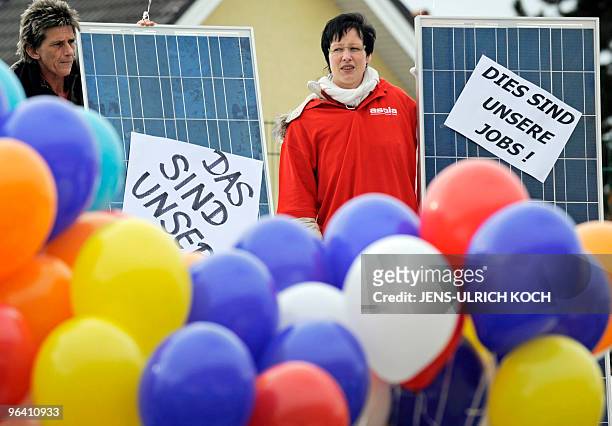 Employees of various solar companies demonstrate with balloons and placards reading "These are our jobs" in Erfurt, eastern Germany on February 4,...