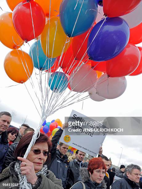 Employees of various solar companies demonstrate with balloons and placards reading "Stop the solar cuts" in Erfurt, eastern Germany on February 4,...