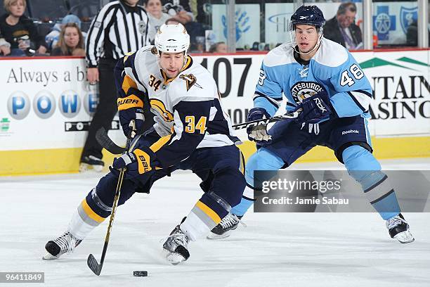 Defenseman Chris Butler of the Buffalo Sabres skates with the puck against forward Tyler Kennedy of the Pittsburgh Penguins on February 1, 2010 at...
