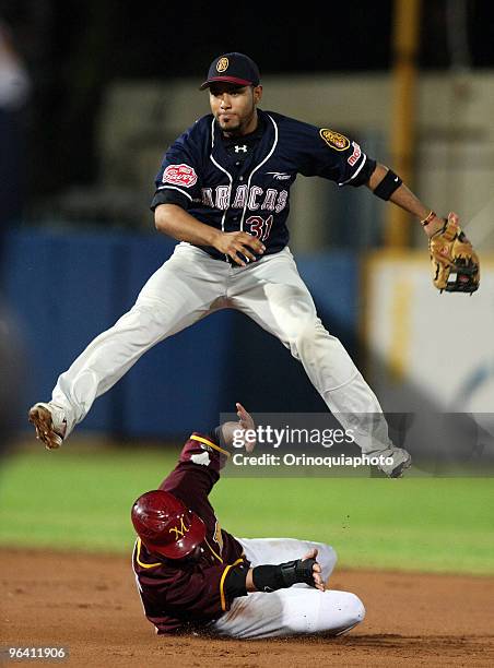 Venezuela's Leones del Caracas player, Gregorio Petit jumps over his counterpart, during a baseball match against Puerto Rico's Los Indios de...