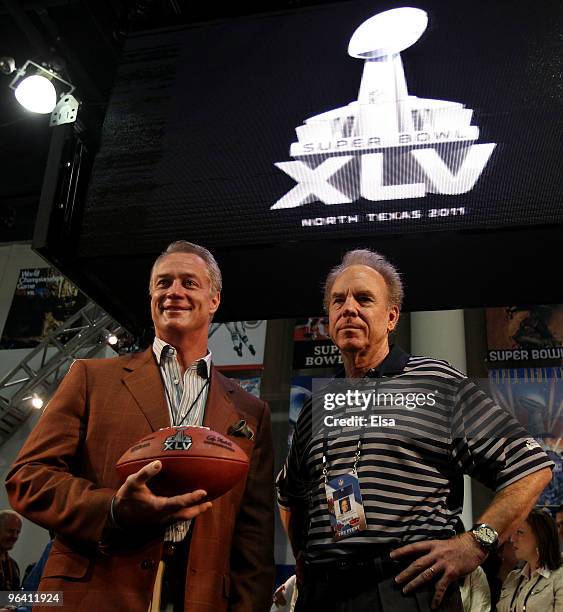 Former NFL fullback, Daryl Johnston, and former NFL quarterback, Roger Staubach, hold a football with the new Super Bowl logo during a press...