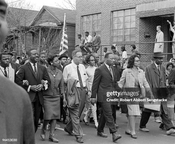 American Civil Rights leader Dr Martin Luther King Jr. And his wife Coretta Scott King lead others during on the Selma to Montgomery marches held in...