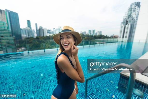 mujer hermosa en la piscina en la azotea - woman pool relax fotografías e imágenes de stock