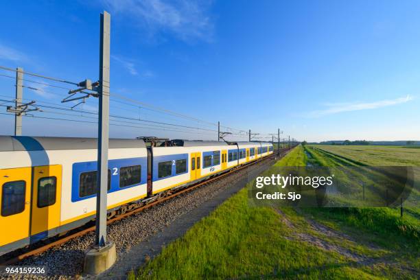 train of the dutch railways driving through a springtime landscape - kampen overijssel stock pictures, royalty-free photos & images