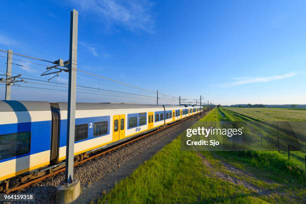 train of the dutch railways driving through a springtime landscape - kampen overijssel stock pictures, royalty-free photos & images