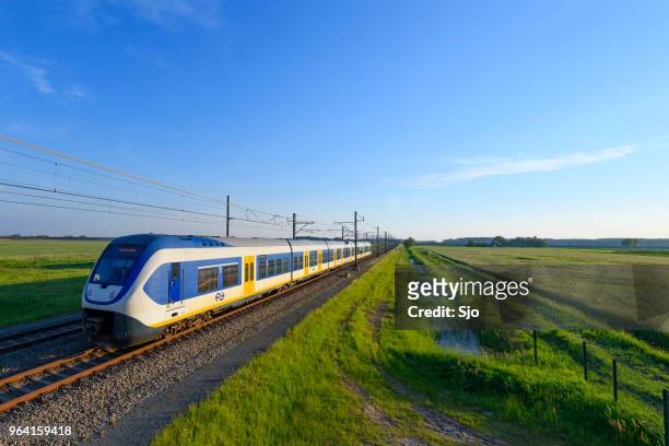 train of the dutch railways driving through a springtime landscape - kampen overijssel stock pictures, royalty-free photos & images