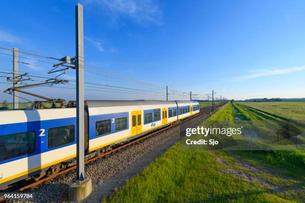 train of the dutch railways driving through a springtime landscape - kampen overijssel stock pictures, royalty-free photos & images