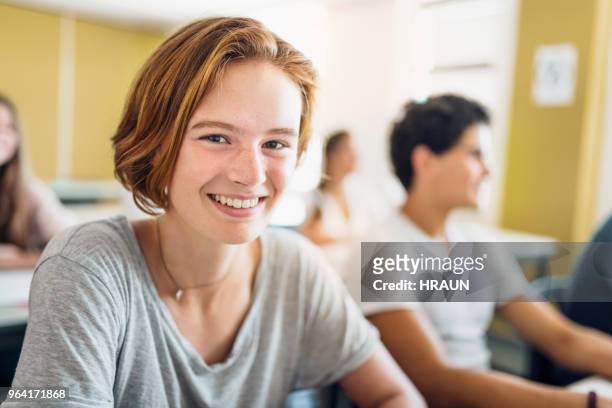 portrait of female student smiling in classroom - student high school stock pictures, royalty-free photos & images