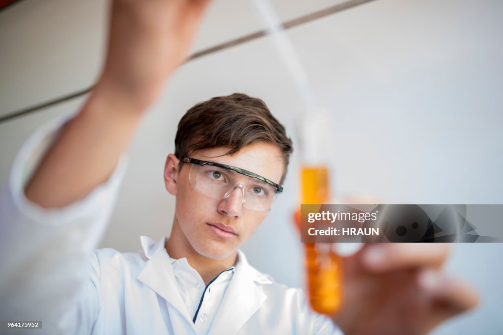High-School-Schüler, die Flüssigkeit in Reagenzglas Tropfen