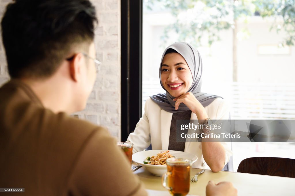 Malaysian man and woman having lunch in a restaurant