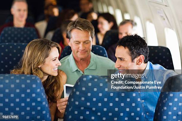 man and woman talking on an airplane - siège d'avion photos et images de collection