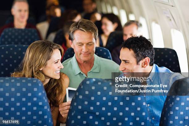man and woman talking on an airplane - banco de avião imagens e fotografias de stock