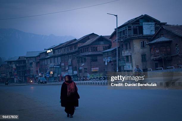 Kashmiri muslim woman negotiates curfew imposed streets on February 04, 2010 in Srinagar, Kashmir, India. Soldiers dressed in riot gear patrolled the...