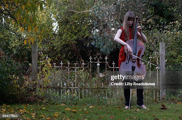 young woman playing cello in garden. - lilly roadstones stock pictures, royalty-free photos & images