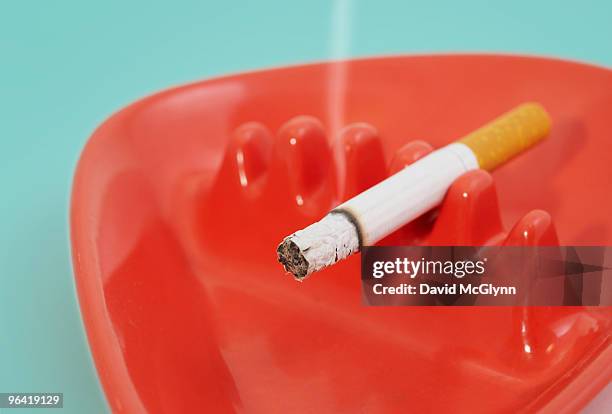 cigarette in ashtray - passive smoking stock pictures, royalty-free photos & images