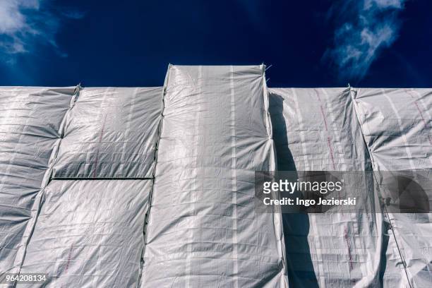 close-up of protective sheeting and scaffolding of construction site - tarpaulin fotografías e imágenes de stock