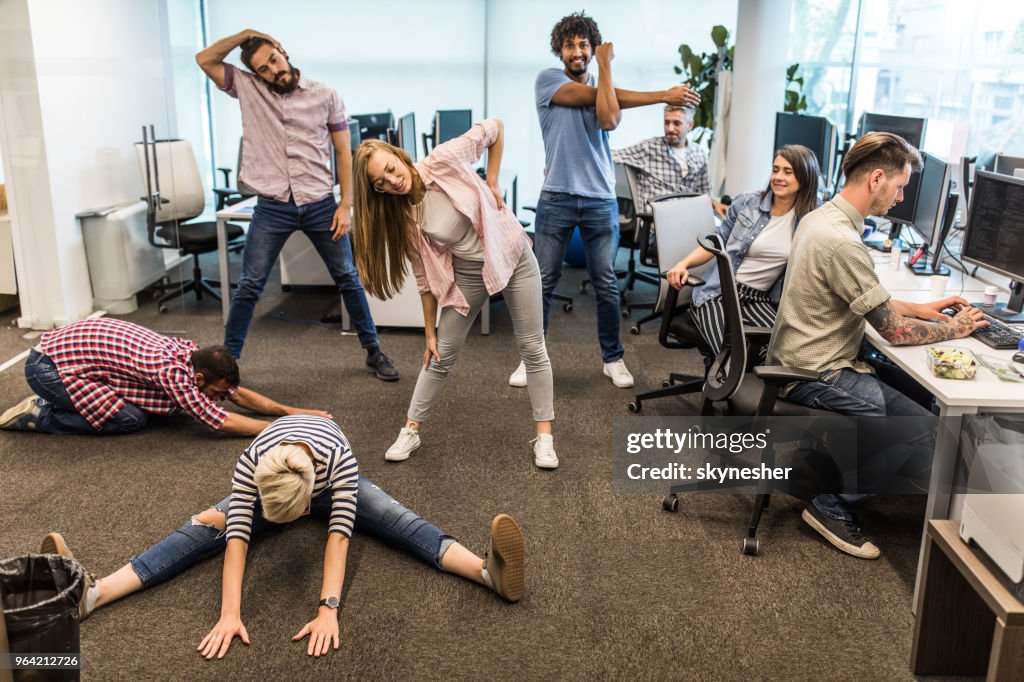 Group of programmers exercising on a break in the office.