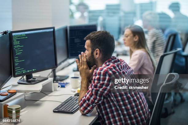 worried programmer having problems while working on new computer program in the office. - upset coworker stock pictures, royalty-free photos & images