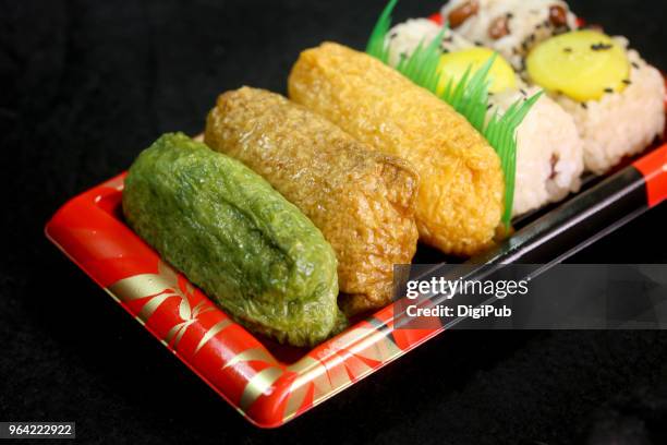 tricolor inarizushi bento in disposable plastic box on black background - inarizushi stock-fotos und bilder