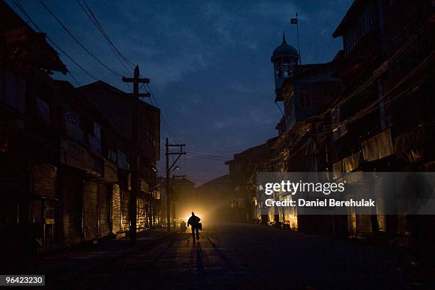 Kashmiri muslim man negotiates curfew imposed streets on February 04, 2010 in Srinagar, Kashmir, India. Soldiers dressed in riot gear patrolled the...