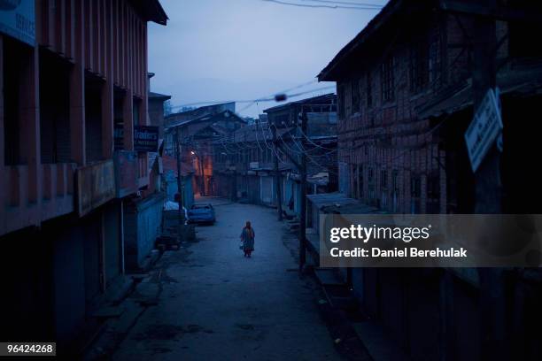 Kashmiri muslim woman negotiates curfew imposed streets on February 04, 2010 in Srinagar, Kashmir, India. Soldiers dressed in riot gear patrolled the...