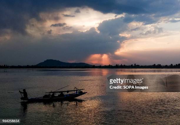 Kashmiri Boatman Rows his boat at sunset on the world famous dal lake in Srinagar.