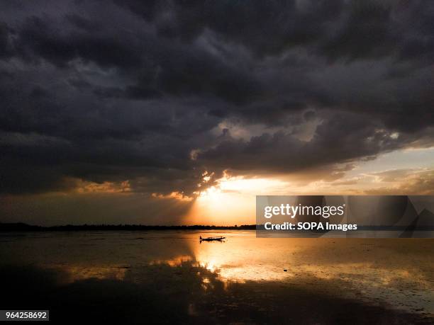 Kashmiri Boatman Rows his boat during sunset on the world famous Dal lake in Srinagar.