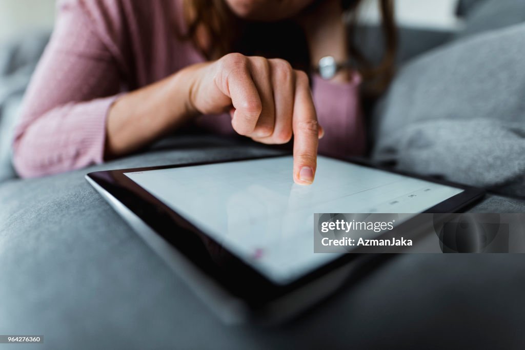 Nahaufnahme einer Frau mit digital-Tablette auf dem sofa