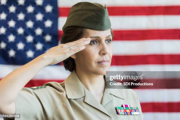 mature female soldier salutes american flag - officer saluting stock pictures, royalty-free photos & images