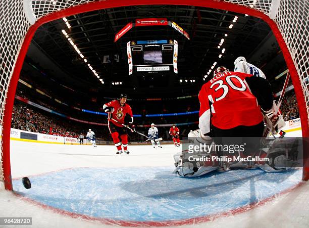 Steve Bernier of the Vancouver Canucks screens Brian Elliott of the Ottawa Senators from a point shot that rings off the post in a game at Scotiabank...